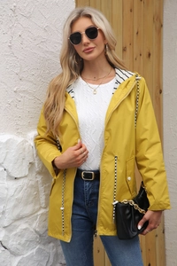Detail of yellow waterproof hooded raincoat featuring striped lining and metal zipper