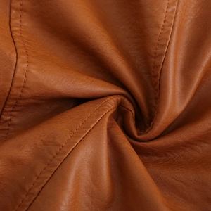Gros plan détaillé du tissu en similicuir marron montrant la texture et les coutures