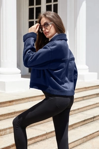 Dettaglio giacca in pelle scamosciata blu scuro con bordo in montone e chiusura a zip