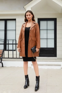 Brown long faux leather trench coat styled with a black dress and leather boots