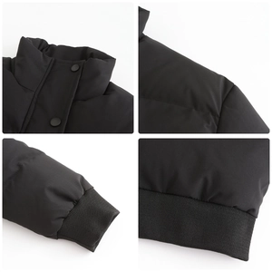 Detail of black puffer jacket showing stand-up collar with snaps and ribbed cuffs