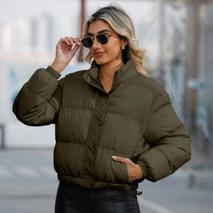 Deep olive green short puffer jacket with high neck for women in a street style view