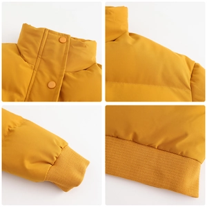 Detail view of ginger yellow puffer jacket with stand collar and ribbed cuffs