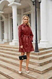 Dettaglio del trench in ecopelle rosso scuro con cintura e tasche a patta