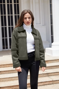 Dettaglio giacca scamosciata verde scuro con colletto in shearling e zip in metallo
