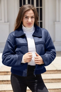 Dettaglio della giacca scamosciata blu navy con risvolti e polsini in pile a contrasto
