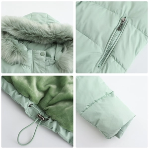 Detail of mint green winter coat featuring faux fur hood and warm fleece lining