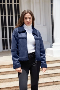 Dettaglio giacca in pelle scamosciata blu scuro con bordo in montone e zip in metallo