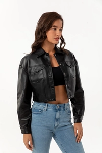 Detailed close-up of a black faux leather jacket featuring classic lapels and flap pockets