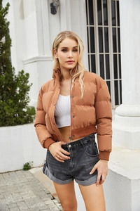Detail of caramel puffer jacket with high collar and ribbed cuffs for women