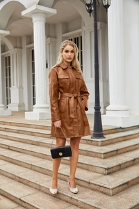 Dettaglio di un trench midi in similpelle marrone con cintura in vita e ampie tasche