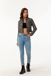 Detail of grey cropped jacket with pockets paired with ripped jeans and black boots