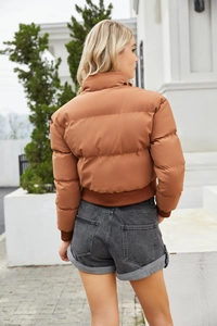 Outdoor shot of the back view of a brown puffer jacket with high collar and ribbed cuffs