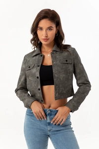 Detail of dark grey faux suede jacket featuring utility pockets and button closure