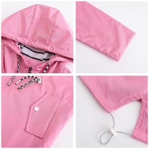 Detail view of pink waterproof trench coat featuring striped lining and drawstrings