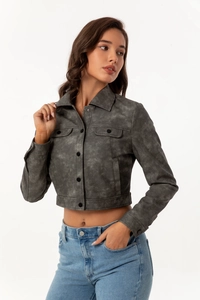 Detail of dark grey cropped jacket showing textured washed fabric and breast pockets