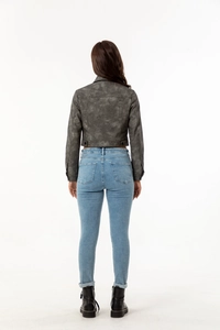 Rear view of women's vintage grey cropped zip-up jacket with slim fit denim jeans