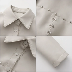 Detailed close-up of beige leather jacket collar, silver studs, and buttons decoration
