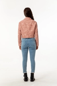 Rear view of women's short faux suede jacket in dusty rose with casual denim and boots