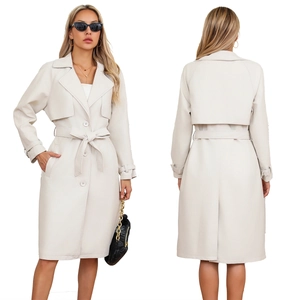 Detail van de crème lange trenchcoat met klassieke revers, knopen en tailleband
