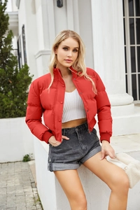 Detail of red padded jacket featuring stand collar, zip closure, and ribbed cuffs