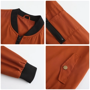 Detailansicht der orangefarbenen Bomberjacke mit Rippkragen, Ärmeltasche und Bündchen