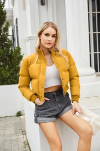 Detail of high collar and snap button closure on a bright yellow padded winter jacket