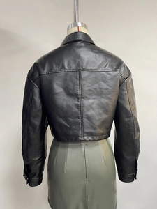Rear view of black faux leather jacket with detailed stitching and snap button cuffs