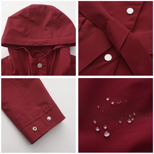 Macro view of burgundy hooded windbreaker showing metal snaps, waist belt and waterproof fabric
