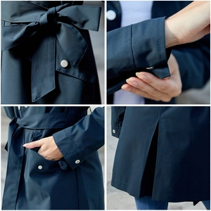 Close-up of waterproof trench coat detailing with belt, buckle cuffs, and pocket