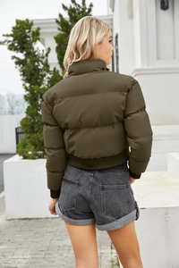 Detail view of the olive green puffer jacket featuring ribbed cuffs and back silhouette