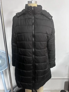 Detail of black water-resistant quilted long coat with a detachable hood and zip closure