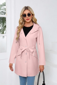 Pink hooded mid-length trench coat for women featuring a waist belt and large flap pockets