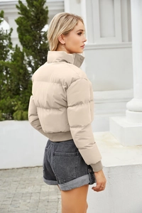 Detailed back view of beige quilted puffer jacket with stand collar and ribbed cuffs