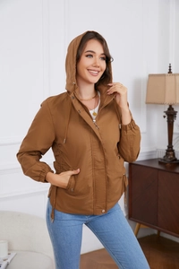 Detailed view of women's hooded jacket with adjustable drawstring waist and windproof cuffs