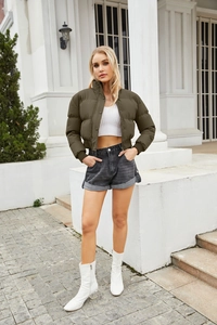 Detail of dark olive short puffer jacket with high collar and ribbed cuffs for women