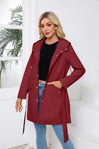 Detail view of dark red hooded trench coat featuring metal snaps and large flap pockets