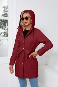 Detail of water-resistant hooded jacket with drawstring waist and metal buttons in dark red