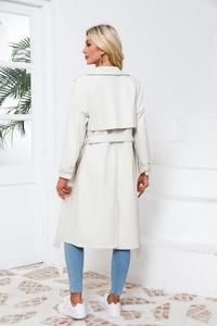 Achteraanzicht van een losse oversized trenchcoat met windflap en tailleriem in beige