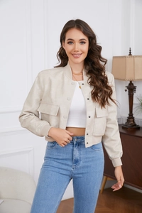 Detail of beige oversized faux suede jacket with large flap pockets and ribbed cuffs