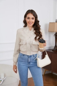 Detail of faux suede jacket showing ribbed hem, stand collar and flap pockets