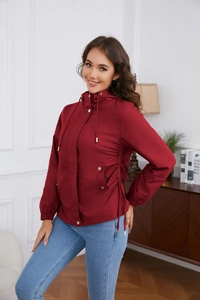 Detail of burgundy hooded jacket featuring metal snap buttons and adjustable waist drawstring