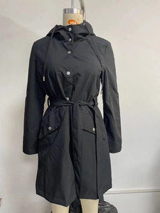 Detail of hooded black windbreaker with metal buttons and adjustable drawstring waist