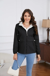 Detail of a black hooded windbreaker featuring a contrasting white inner lining and metal zipper