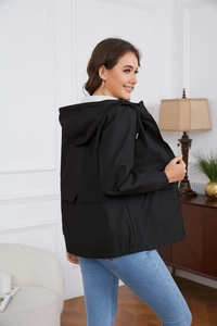 Close-up of black hooded windbreaker jacket with zipper closure and drawstring details