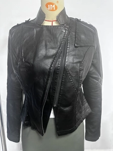 Detail of a slim-fit black faux leather jacket featuring metal zippers and shoulder epaulettes