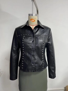 Detail of silver rivets and button closure on black leather jacket for women