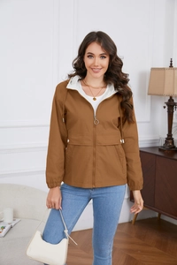 Detail of a brown hooded jacket with contrasting white lining and large flap pockets