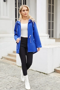 Outdoor shot of a royal blue women's hooded raincoat with stylish striped lining detail