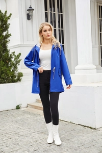 Outdoor view of bright blue waterproof hooded raincoat with drawstring waist and pockets